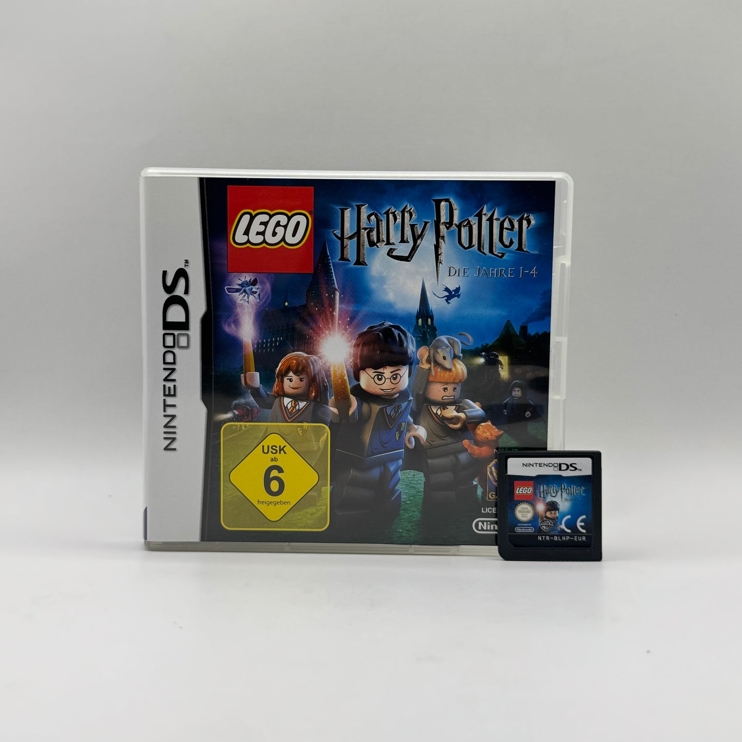 Verpackung des Nintendo DS-Spiels LEGO Harry Potter: Die Jahre 1–4, ein Action-Adventure-Spiel, in dem Spieler die ersten vier Schuljahre von Harry Potter in LEGO-Form erleben, Rätsel lösen und Zaubersprüche anwenden.