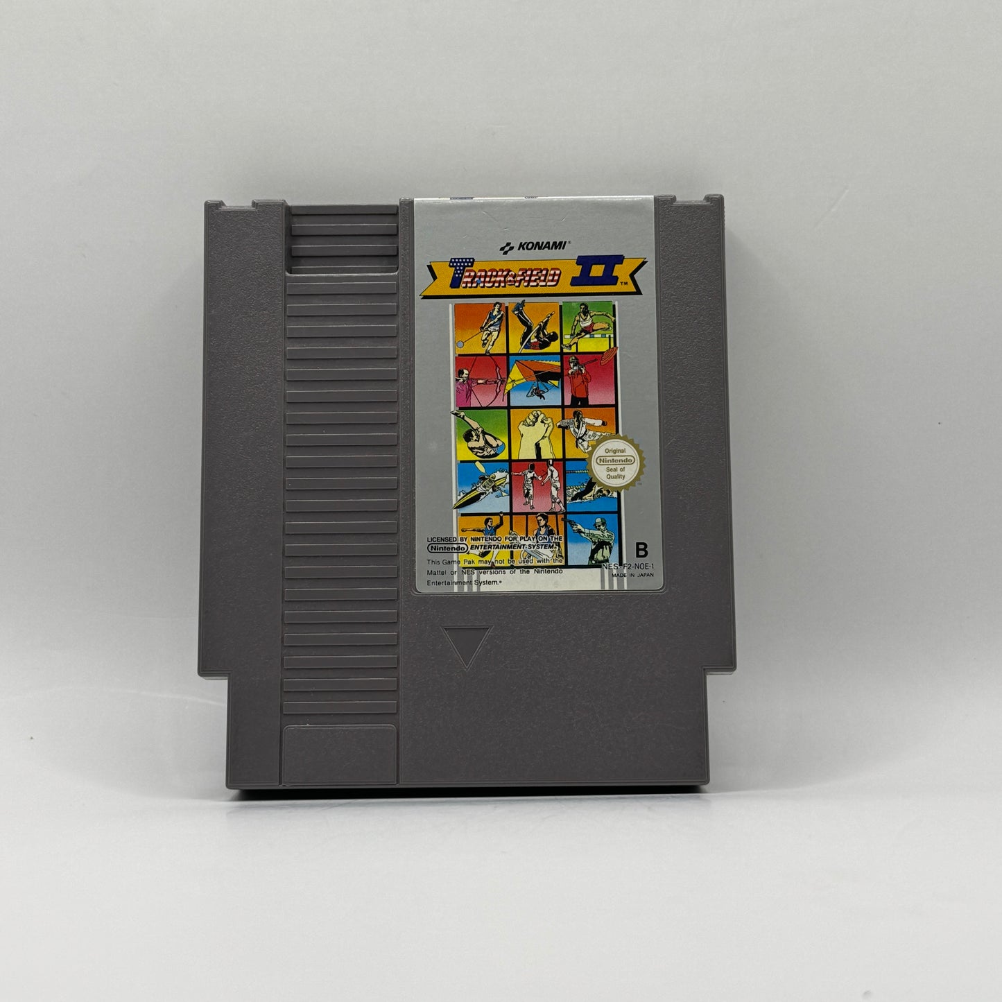 Spielmodul des Nintendo Entertainment System-Spiels Track & Field II, eine Sportspiel-Sammlung, in der Spieler in verschiedenen olympischen Disziplinen ihre Reaktionsgeschwindigkeit und Geschicklichkeit unter Beweis stellen.