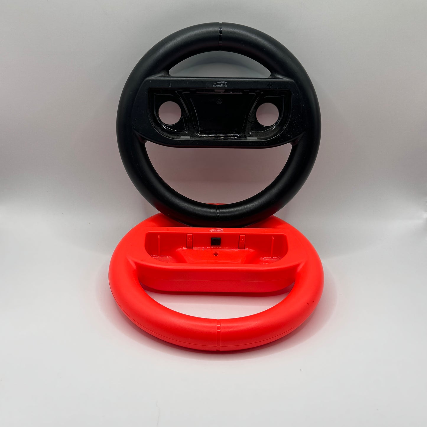 Zwei Nintendo Switch Lenkrad-Aufsätze für Joy-Con-Controller, verwendet für realistischeres Spielen bei Rennspielen.