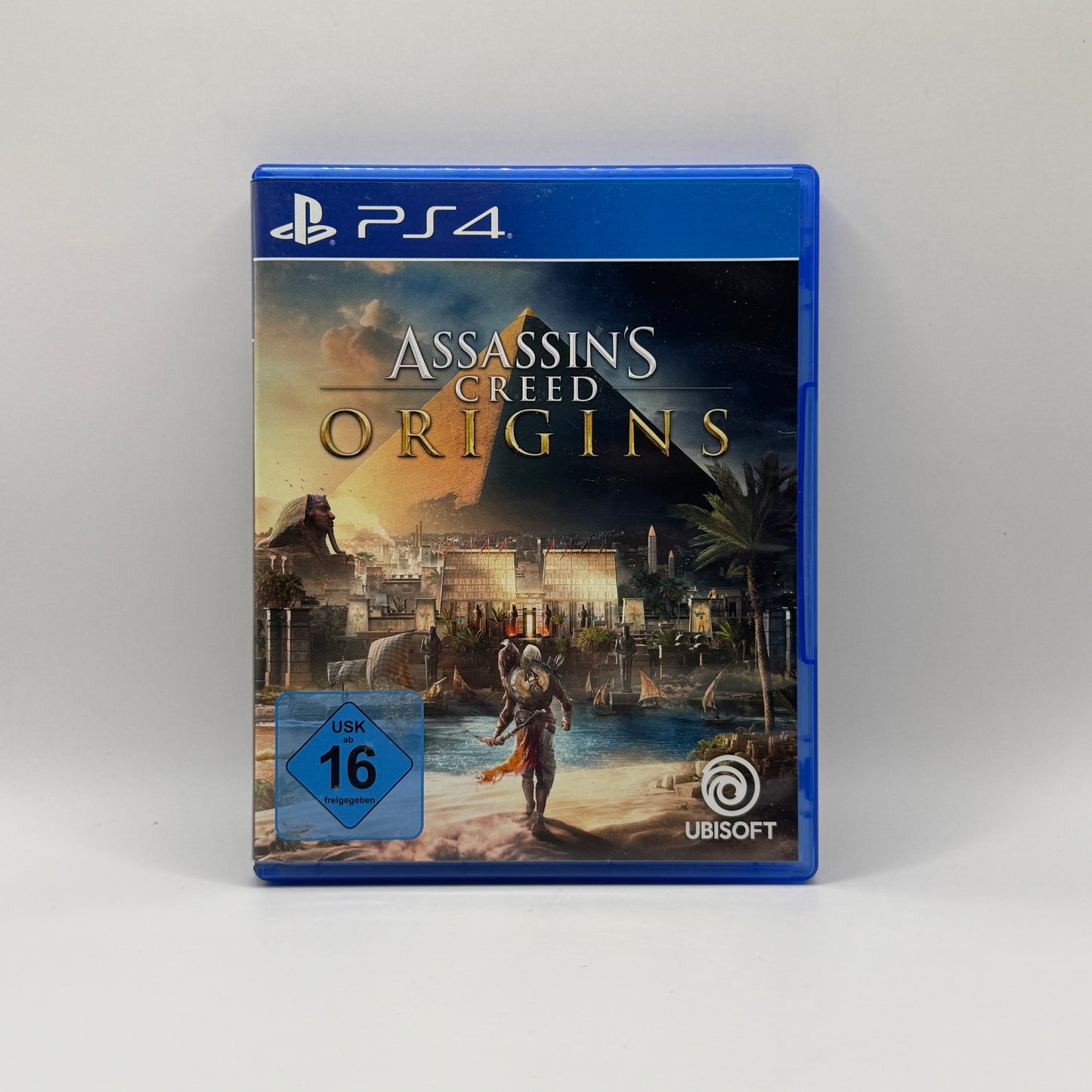 Verpackung des PS4-Spiels Assassin’s Creed Origins, ein Action-Adventure-Rollenspiel, in dem Spieler als Bayek das alte Ägypten erkunden, Missionen erfüllen und gegen Feinde kämpfen.