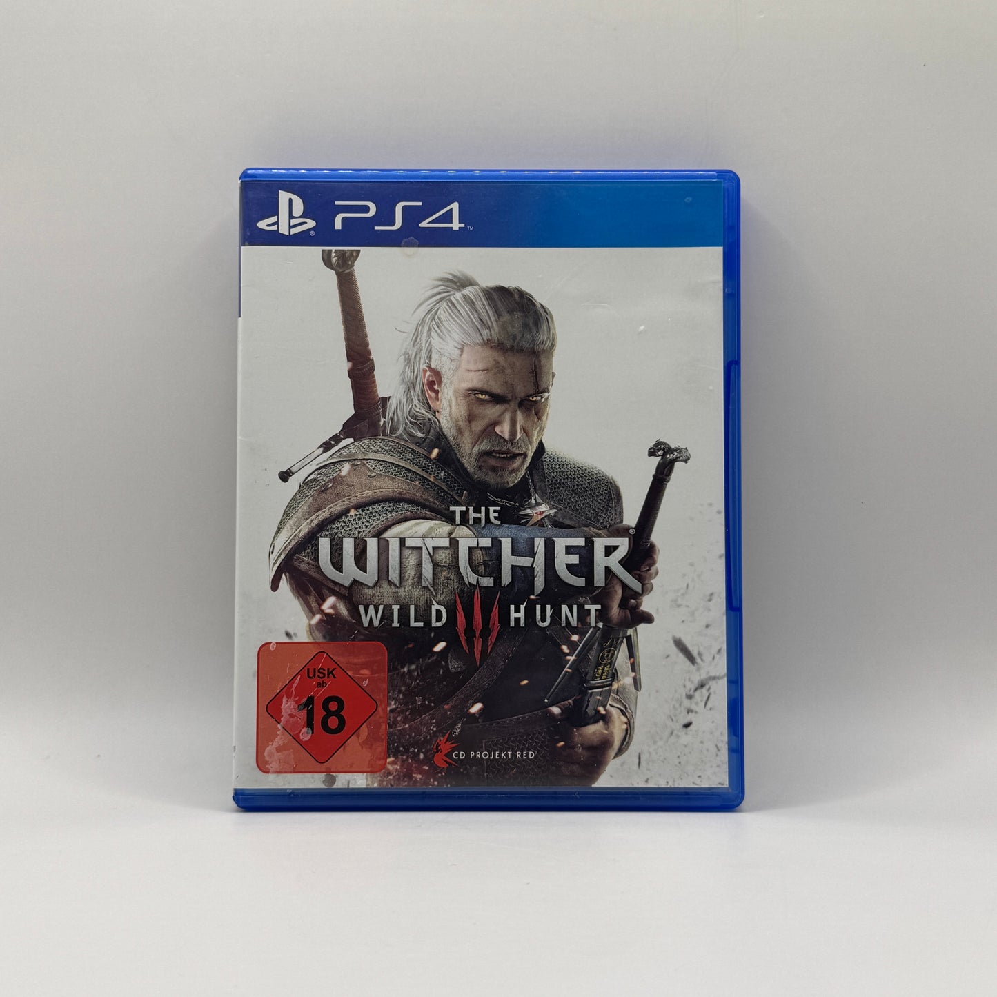 Verpackung des PS4-Spiels The Witcher 3: Wild Hunt, ein Open-World-Rollenspiel, in dem Spieler als Hexer Geralt von Riva Monster jagen, Quests erfüllen und Entscheidungen in einer detailreichen Fantasy-Welt treffen.