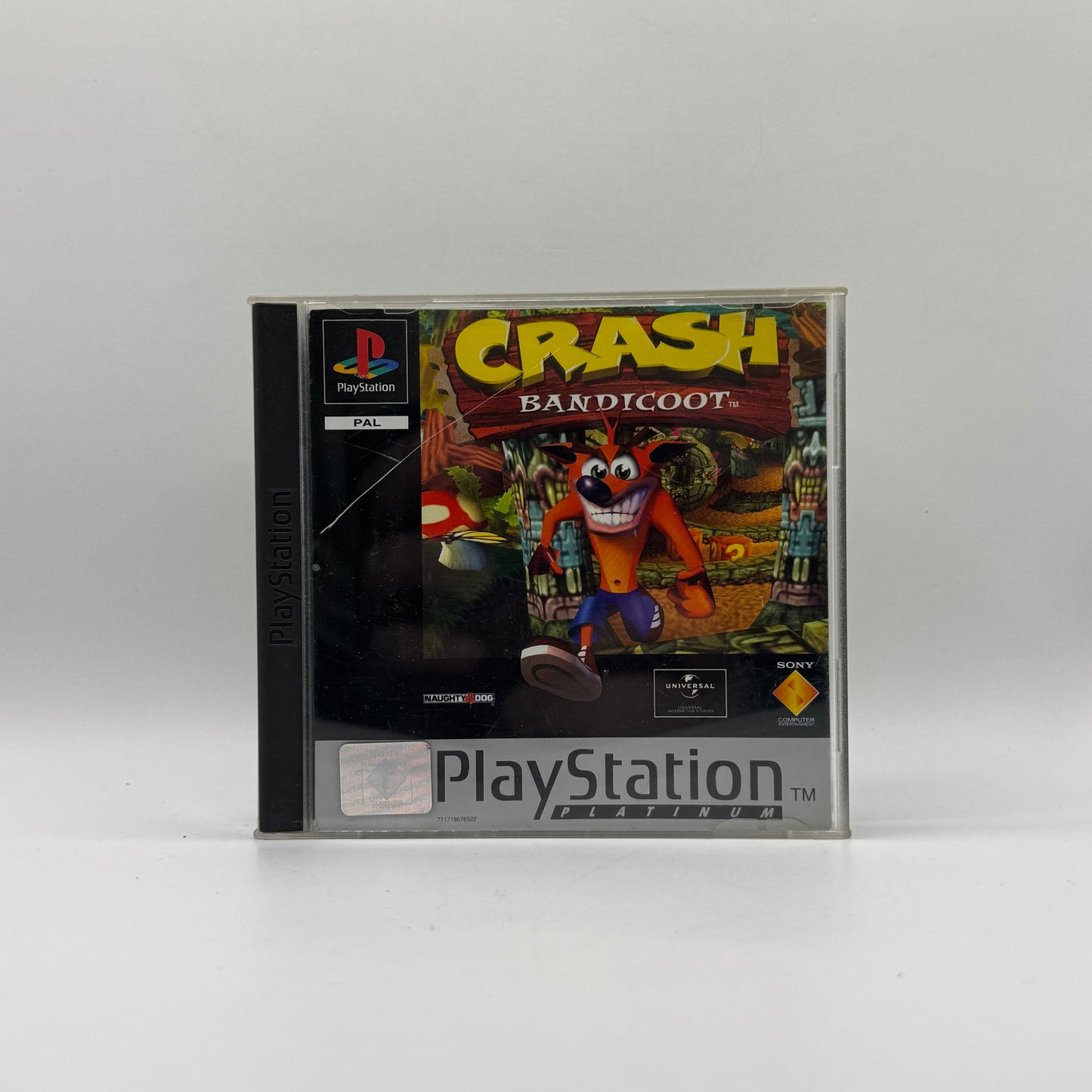 Verpackung des PS1-Spiels Crash Bandicoot, ein 3D-Jump’n’Run-Klassiker, in dem Spieler den Beuteldachs Crash durch farbenfrohe Level steuern, Hindernisse überwinden und Gegner besiegen.