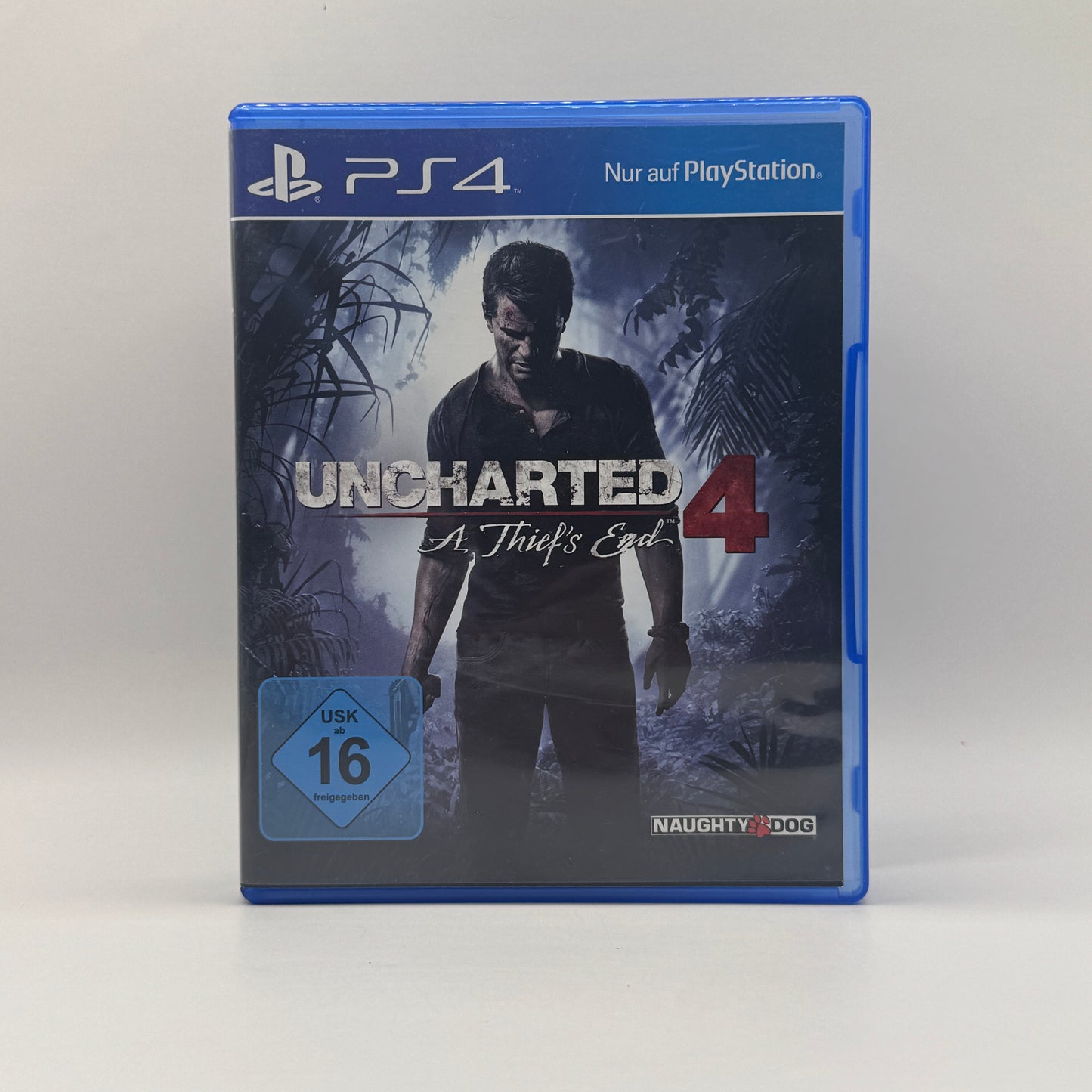 Verpackung des PS4-Spiels Uncharted 4: A Thief’s End, ein Action-Adventure, in dem Spieler Schatzjäger Nathan Drake auf ein weltweites Abenteuer mit Kämpfen, Kletterpassagen und Rätseln begleiten.