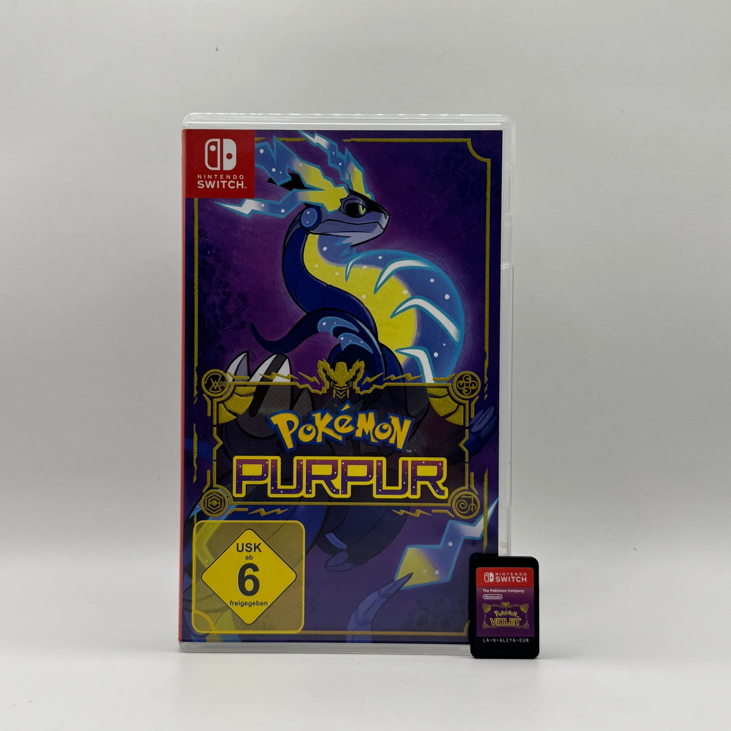 Verpackung des Nintendo Switch-Spiels Pokémon Purpur, ein Open-World-Rollenspiel, in dem Spieler die Paldea-Region erkunden, Pokémon fangen, trainieren und an Kämpfen teilnehmen.