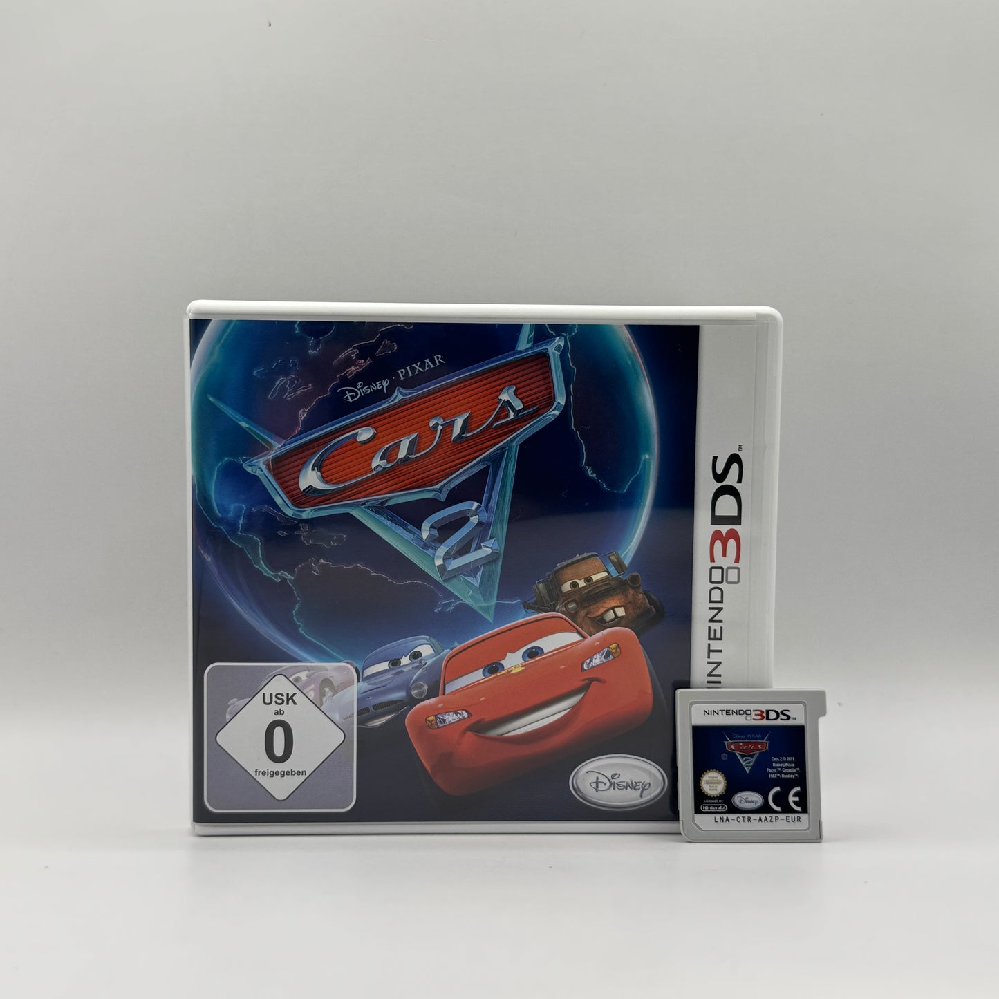 Verpackung des Nintendo 3DS-Spiels Cars 2, ein Rennspiel basierend auf dem gleichnamigen Disney-Pixar-Film, in dem Spieler mit den bekannten Autos um die Welt rasen.