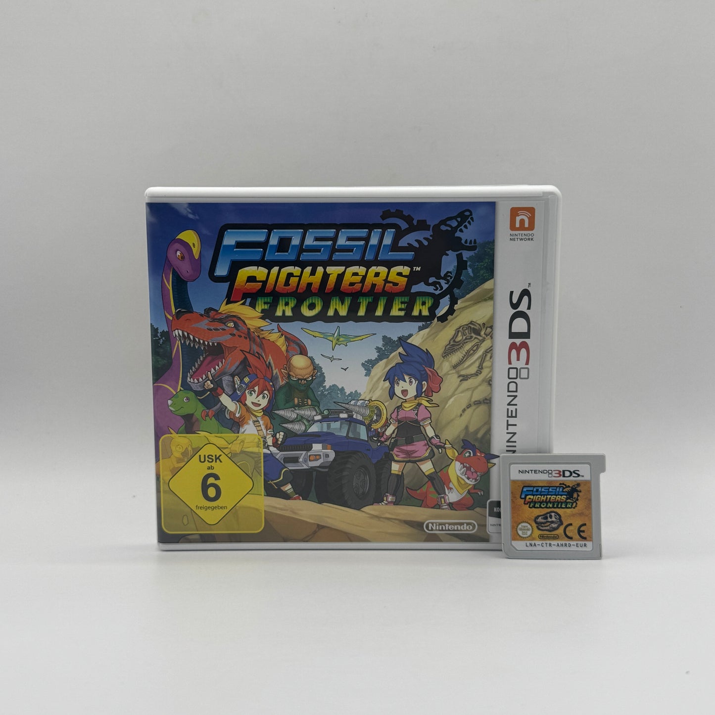 Verpackung des Nintendo 3DS-Spiels Fossil Fighters Frontier, ein Rollenspiel, in dem Spieler Fossilien ausgraben, Dinosaurier zum Leben erwecken und in rundenbasierten Kämpfen antreten.