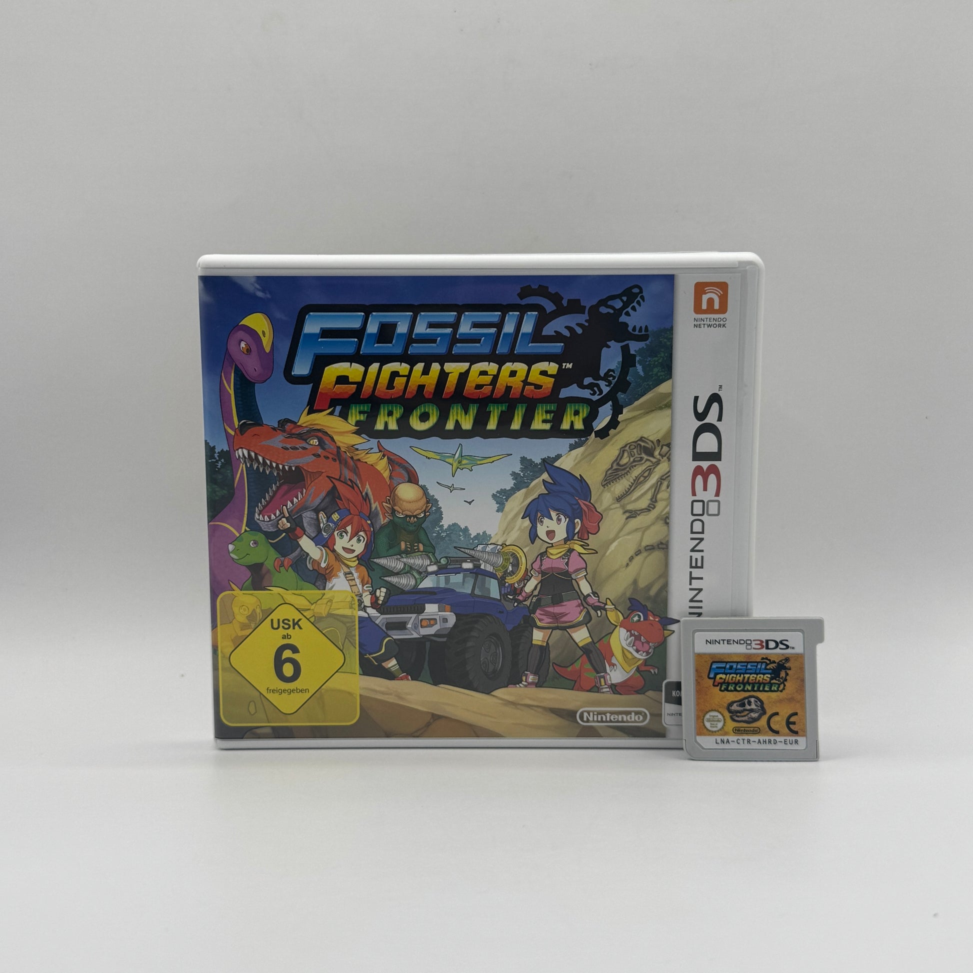 Verpackung des Nintendo 3DS-Spiels Fossil Fighters Frontier, ein Rollenspiel, in dem Spieler Fossilien ausgraben, Dinosaurier zum Leben erwecken und in rundenbasierten Kämpfen antreten.