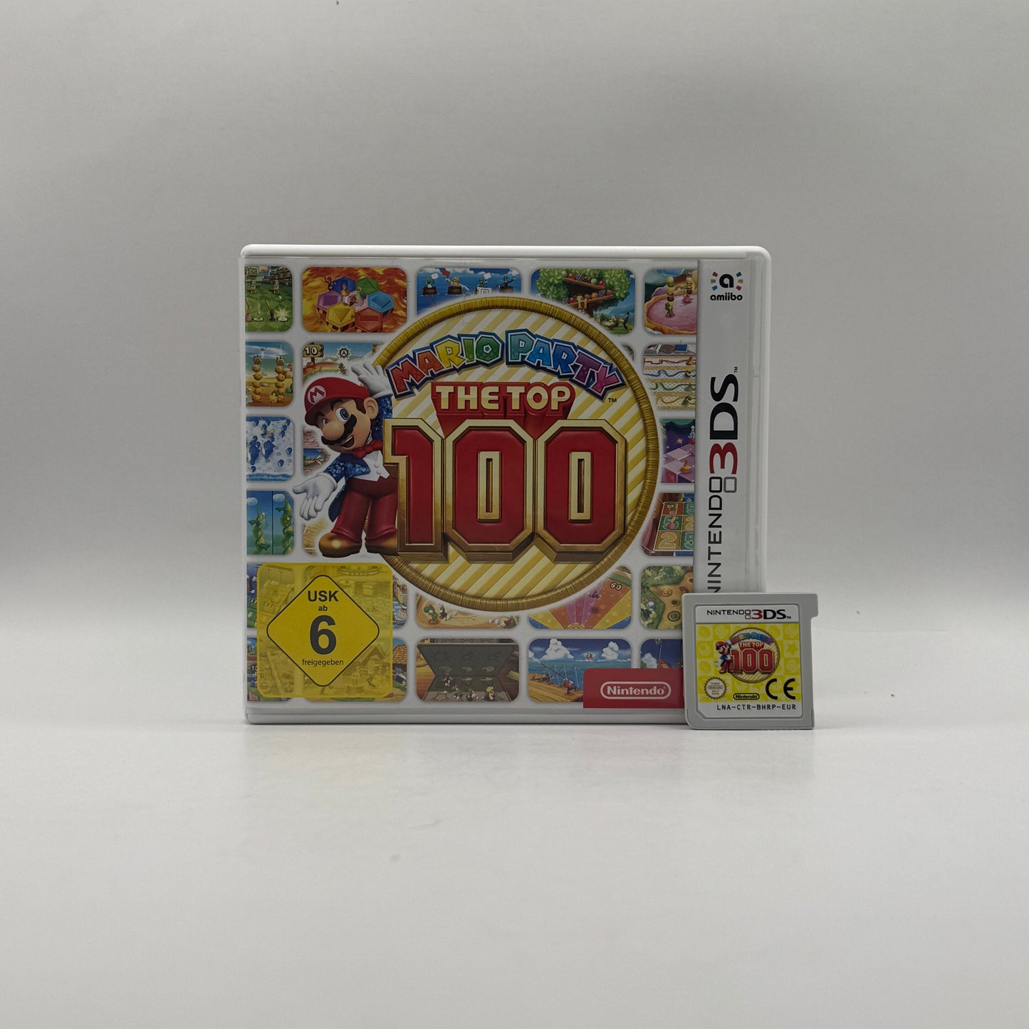 Verpackung des Nintendo 3DS-Spiels Mario Party: The Top 100, ein Partyspiel mit einer Sammlung der 100 beliebtesten Minispiele aus der Mario-Party-Reihe, spielbar allein oder im Mehrspielermodus.