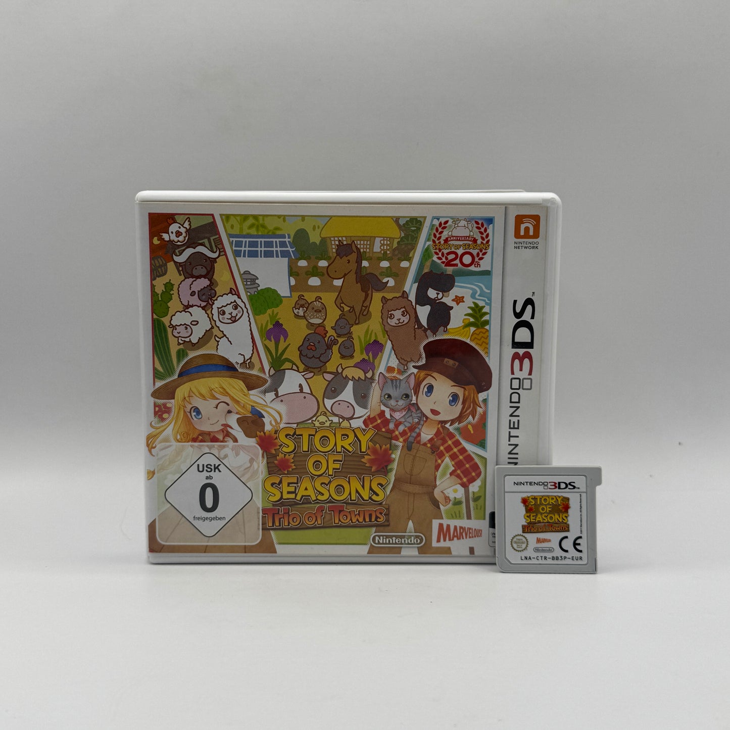 Verpackung des Nintendo 3DS-Spiels Story of Seasons: Trio of Towns, eine Lebens- und Farmsimulation, in der Spieler einen Bauernhof bewirtschaften, Tiere versorgen und Beziehungen zu Bewohnern aus drei verschiedenen Städten aufbauen.