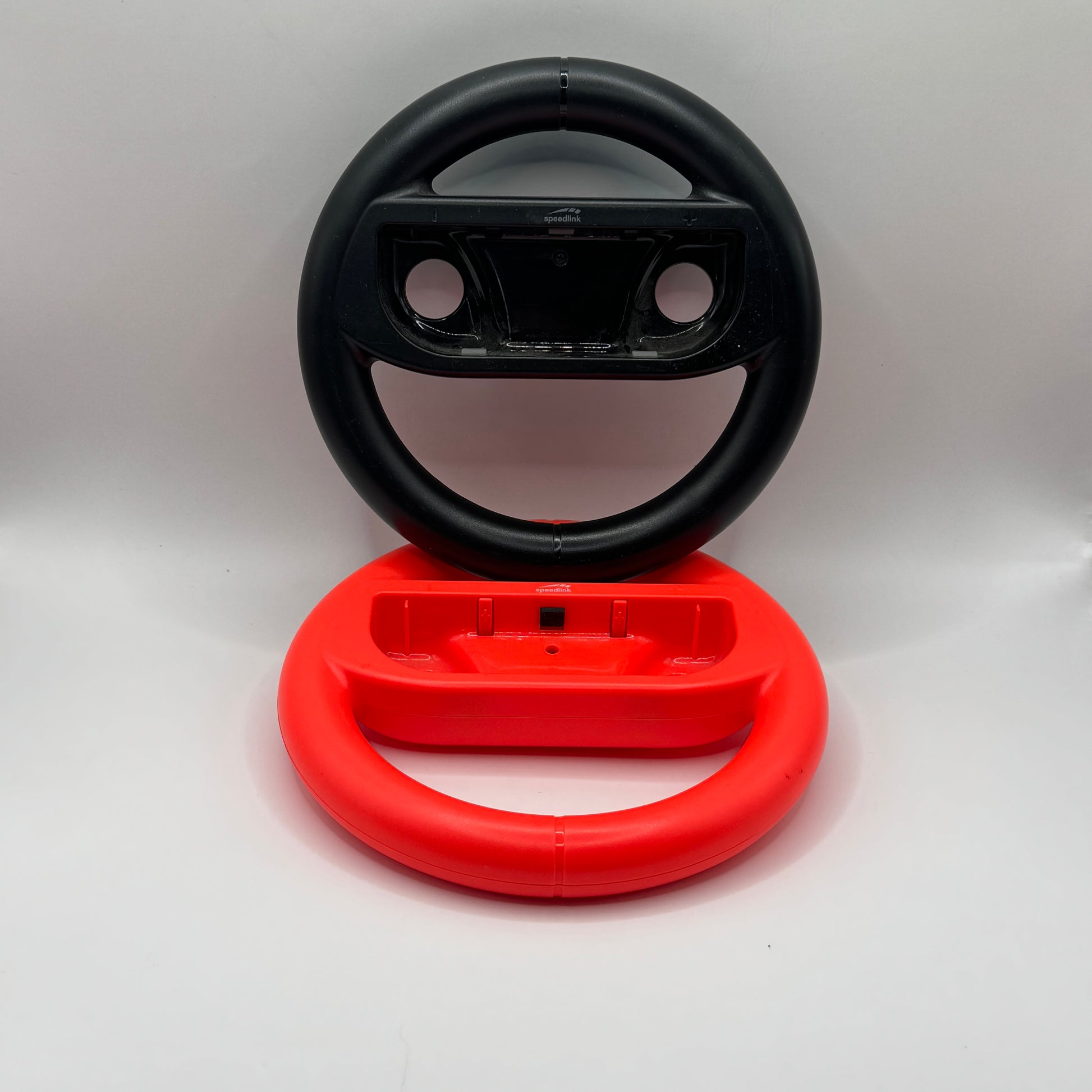 Zwei Nintendo Switch Lenkrad-Aufsätze für Joy-Con-Controller, verwendet für realistischeres Spielen bei Rennspielen.