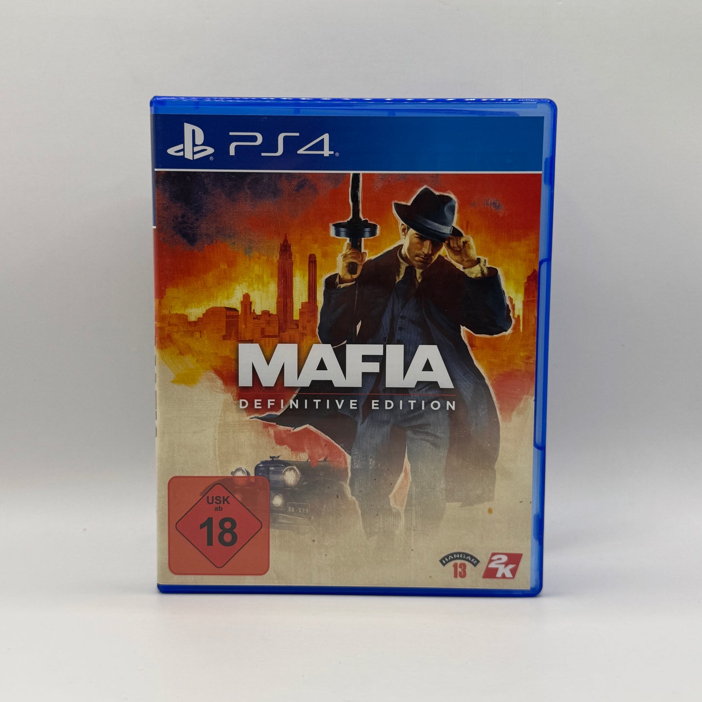 Verpackung des PS4-Spiels Mafia: Definitive Edition, ein Action-Adventure, in dem Spieler als Tommy Angelo in den 1930er-Jahren die Unterwelt von Lost Heaven erleben, Missionen erfüllen und kriminelle Aktivitäten ausführen.
