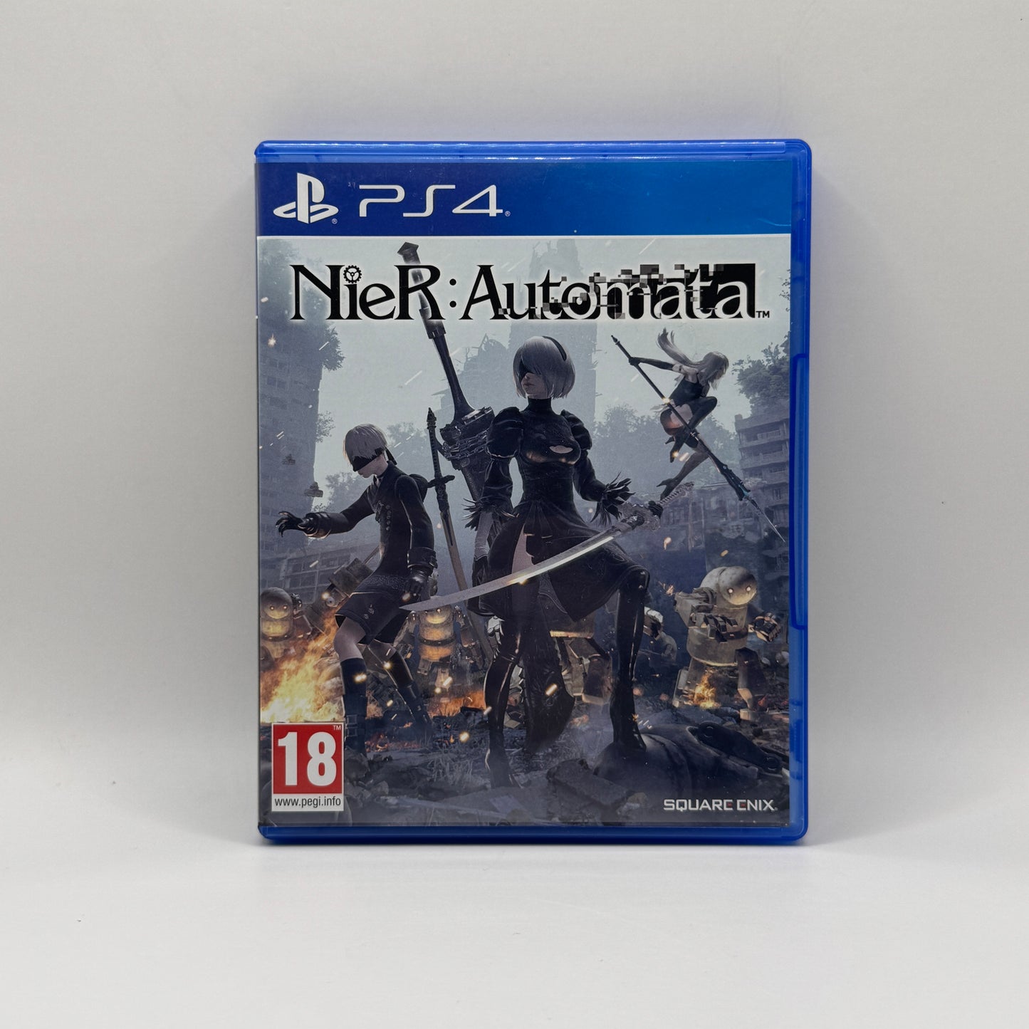 Verpackung des PS4-Spiels Nier: Automata, ein Action-Rollenspiel, in dem Spieler als Androiden 2B, 9S und A2 gegen Maschinenwesen kämpfen und die Geheimnisse einer postapokalyptischen Welt entdecken.