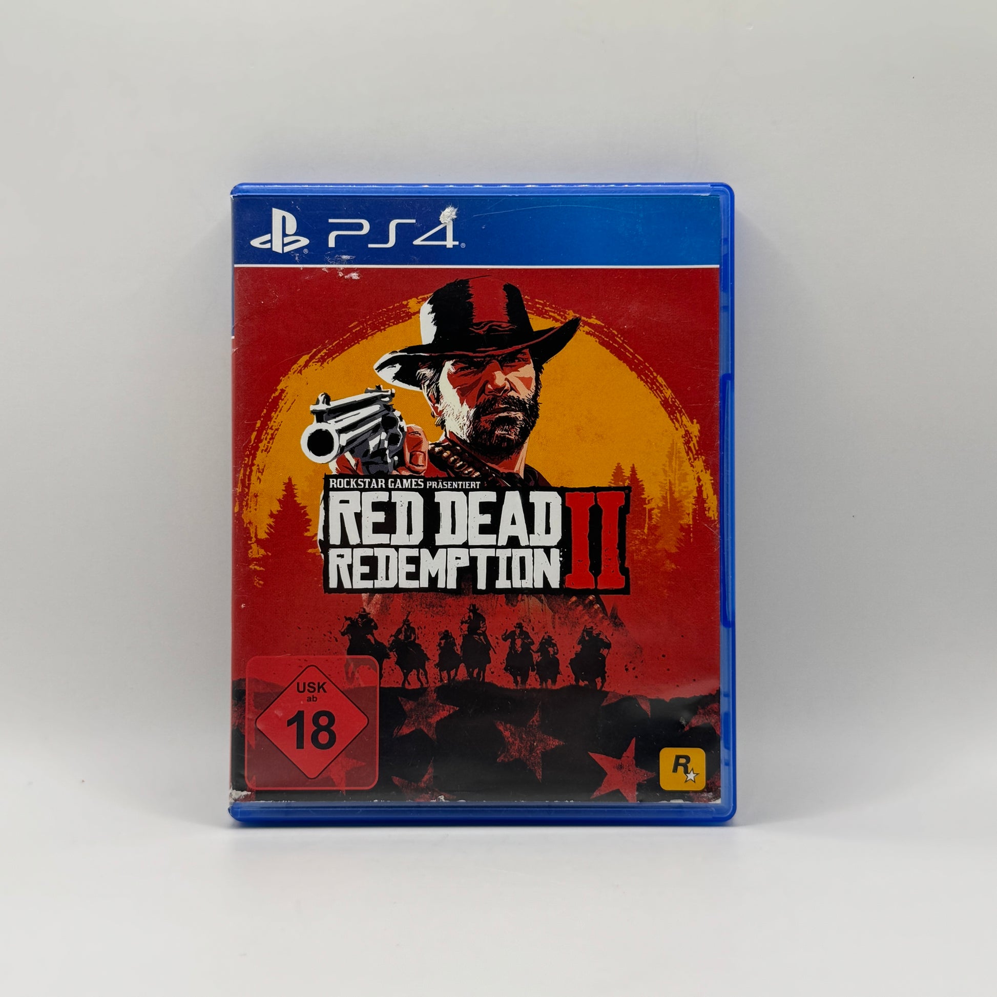 Verpackung des PS4-Spiels Red Dead Redemption 2, ein Open-World-Action-Adventure, in dem Spieler als Arthur Morgan die Wildwest-Welt erkunden, Missionen erfüllen und sich mit Gesetzlosen und Rivalen auseinandersetzen.