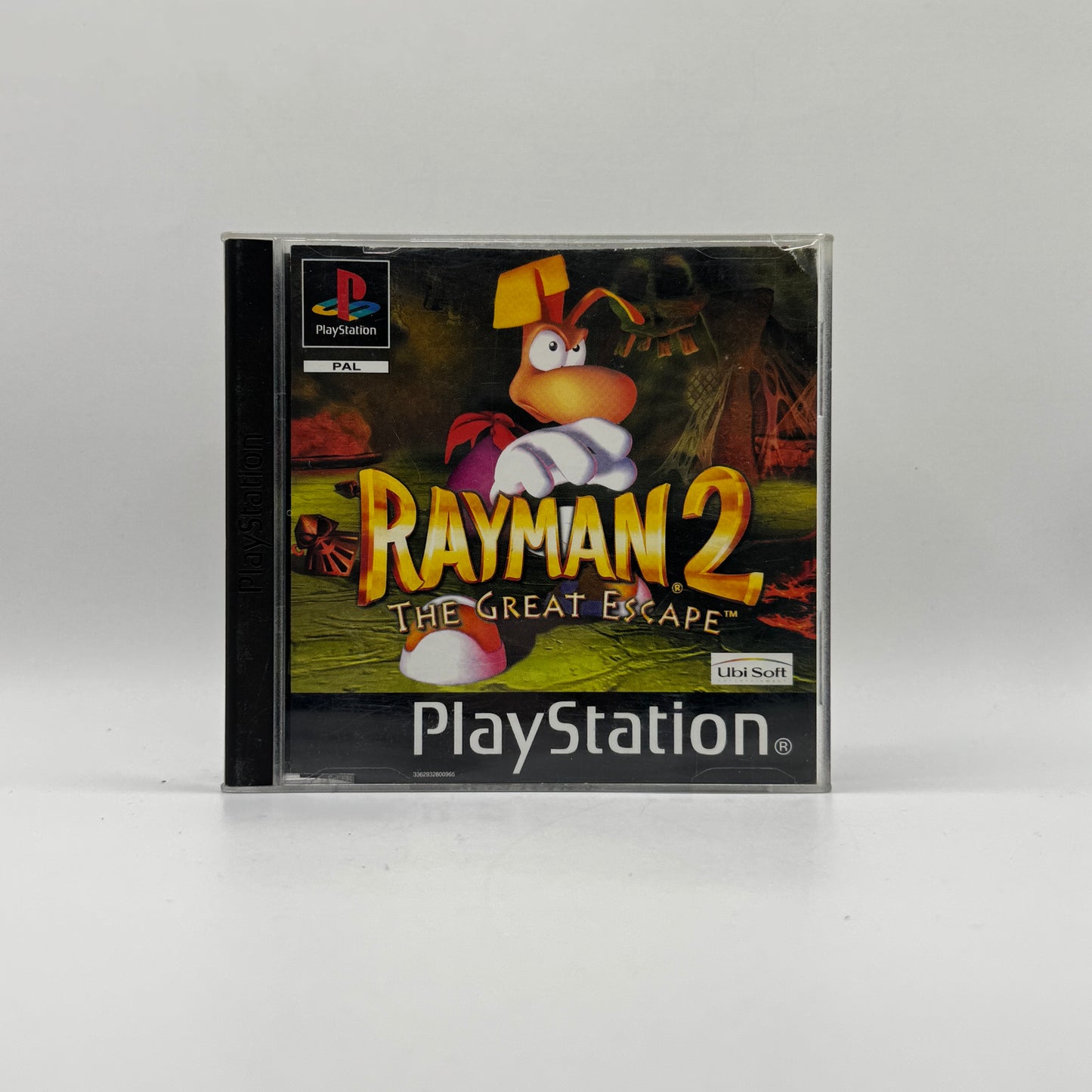 Verpackung des PS1-Spiels Rayman 2: The Great Escape, ein 3D-Platformer, in dem Spieler Rayman durch abwechslungsreiche Welten steuern, Gegner besiegen und Rätsel lösen.