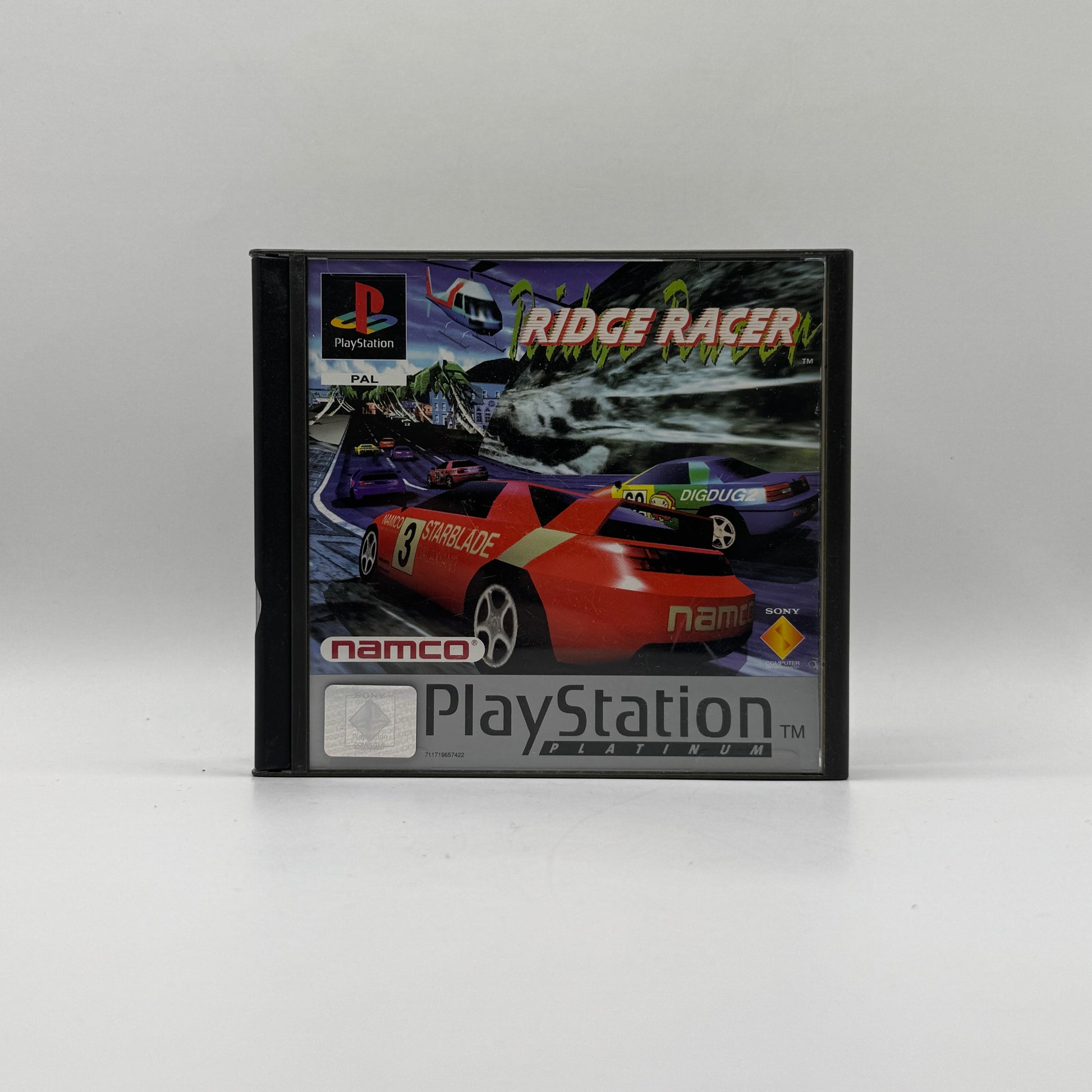 Verpackung des PS1-Spiels Ridge Racer, ein Arcade-Rennspiel mit schnellen Drifts, ikonischen Strecken und elektronischem Soundtrack.