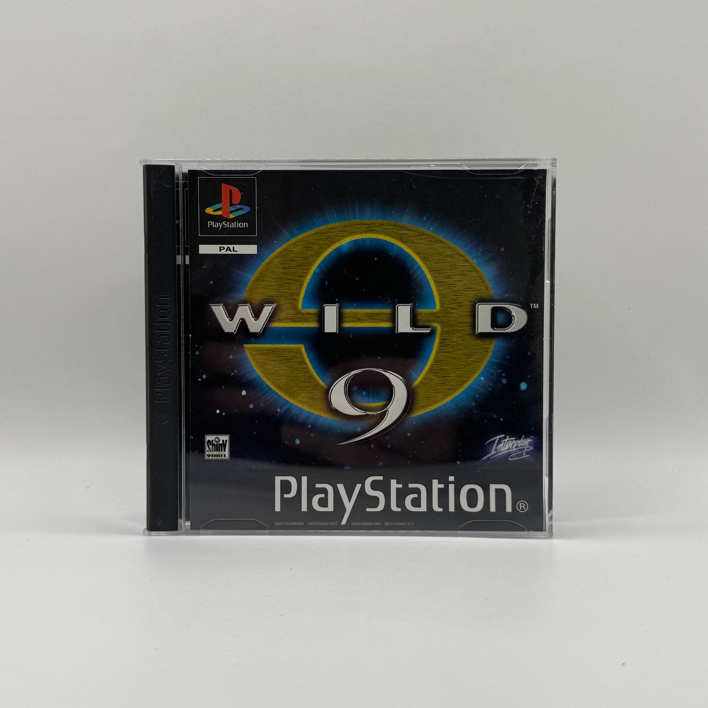 Verpackung des PS1-Spiels Wild 9, ein Action-Plattformer mit Comicstil, in dem Spieler den Kopfgeldjäger Wex Major durch fremde Planeten steuern und Gegner mit einer Energiewaffe besiegen.