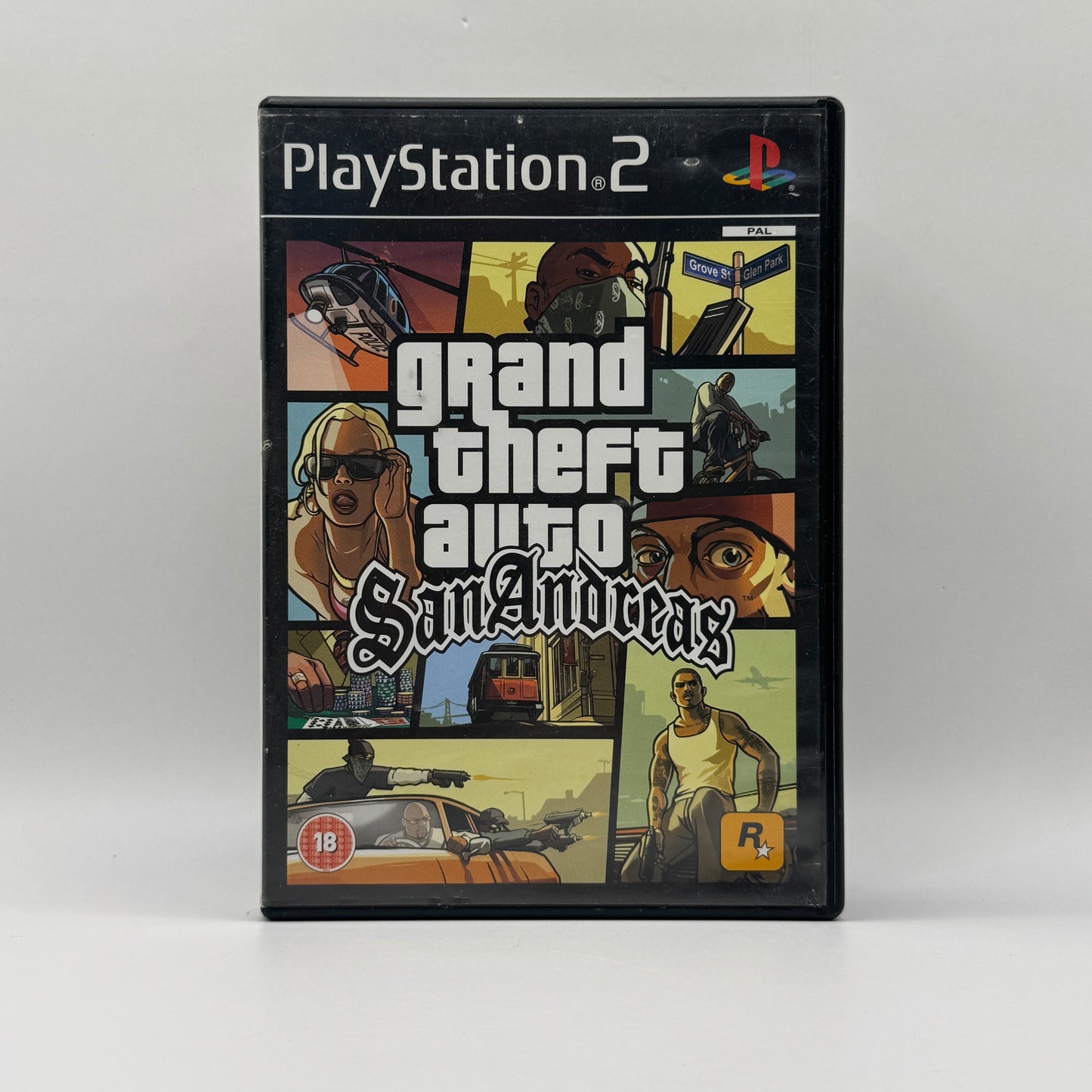 Verpackung des PS2-Spiels Grand Theft Auto: San Andreas, ein Open-World-Actionspiel, in dem Spieler als CJ die Städte San Andreas erkunden, Missionen erfüllen und kriminelle Aktivitäten ausführen.
