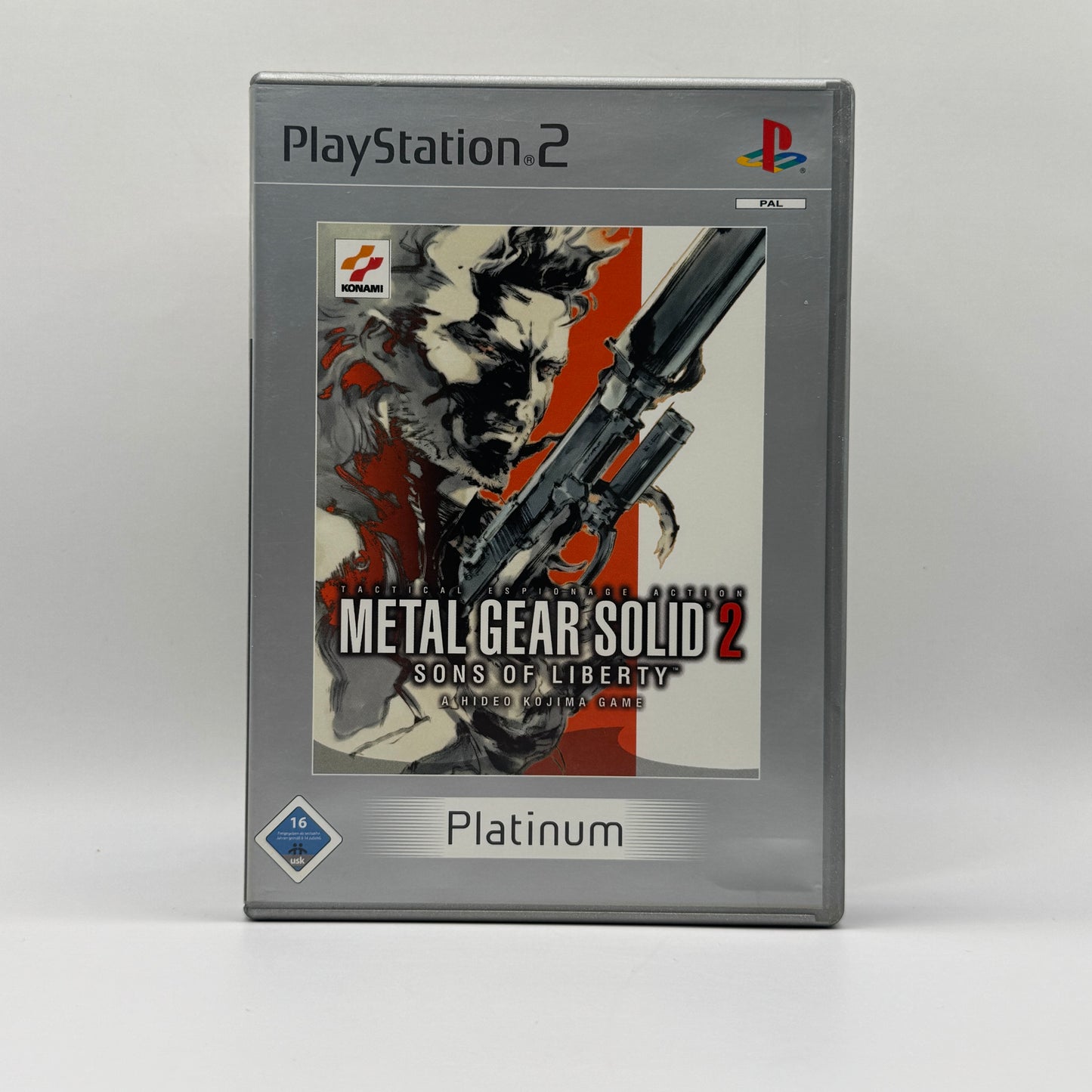 Verpackung des PS2-Spiels Metal Gear Solid 2: Sons of Liberty in der Platinum-Edition, ein Stealth-Action-Spiel, in dem Spieler verdeckte Missionen absolvieren und eine komplexe Story erleben.