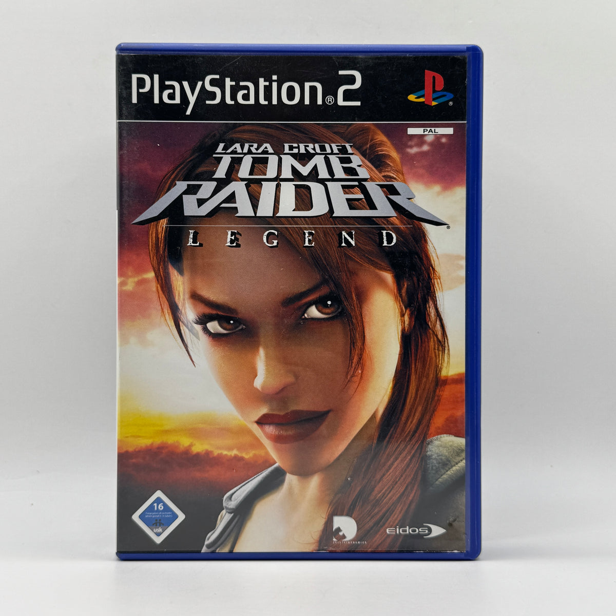 Verpackung des PS2-Spiels Tomb Raider: Legend, ein Action-Adventure, in dem Spieler als Lara Croft verschiedene Schauplätze erkunden, Rätsel lösen und sich gegen zahlreiche Gegner behaupten.