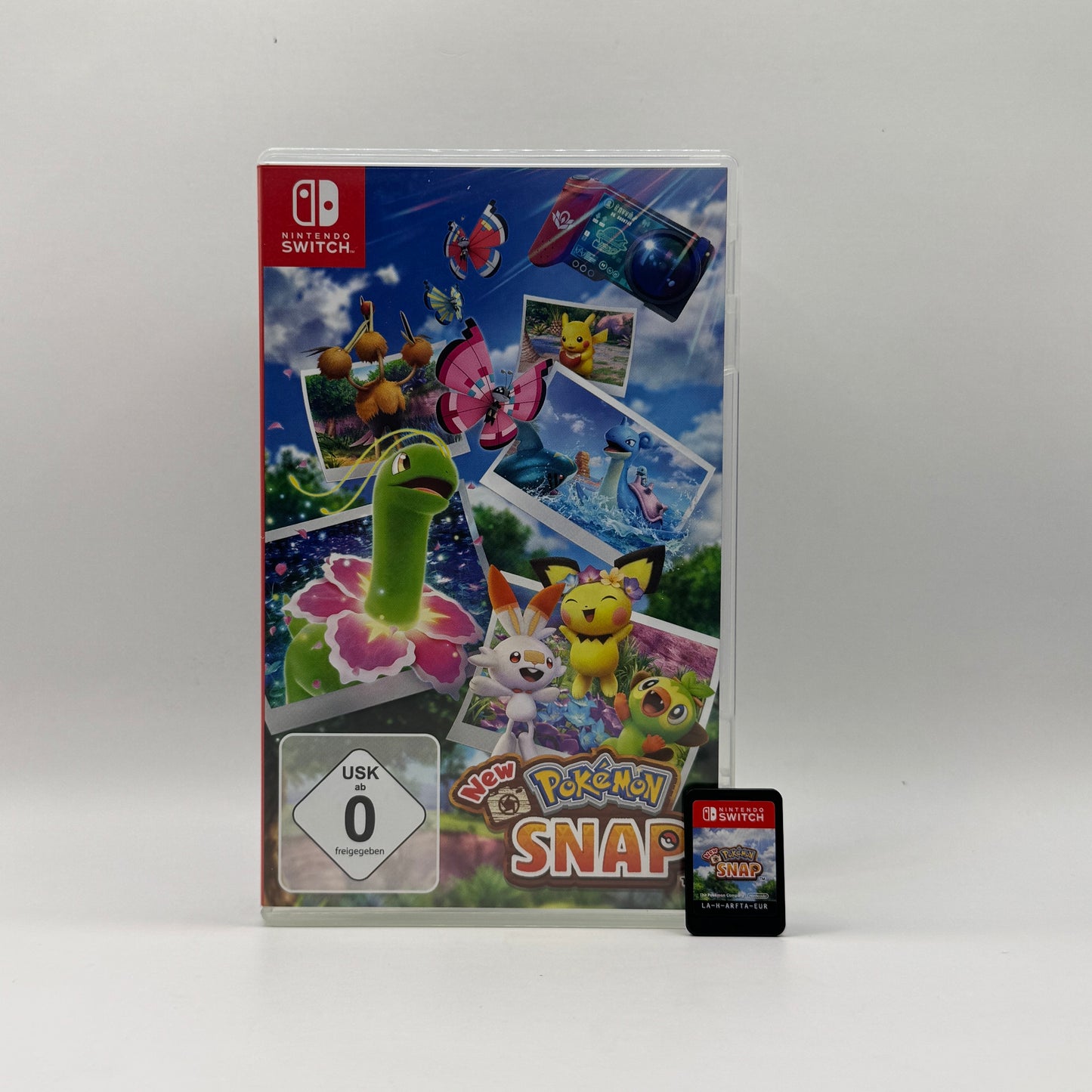 Verpackung des Nintendo Switch-Spiels New Pokémon Snap, ein Abenteuer- und Fotospiel, in dem Spieler Pokémon in ihrer natürlichen Umgebung beobachten, fotografieren und Punkte für gelungene Aufnahmen sammeln.