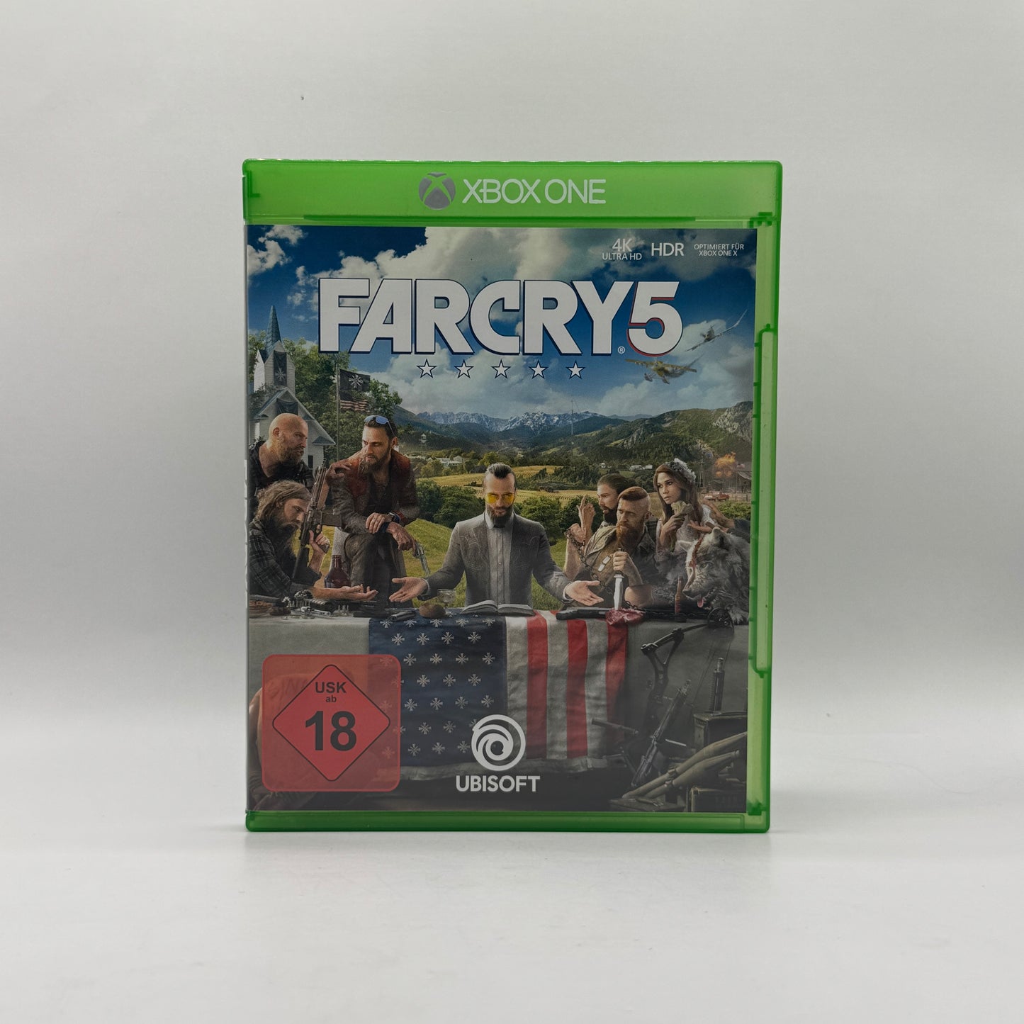 Verpackung des Xbox-One-Spiels Far Cry 5, ein Open-World-Action-Adventure, in dem Spieler eine ländliche Region erkunden und gegen eine fanatische Sekte kämpfen.